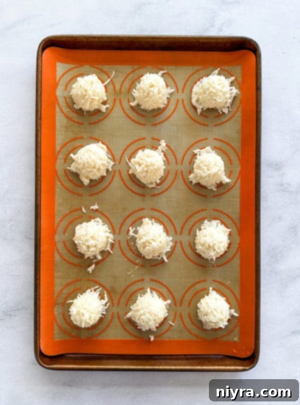 Dropping rounded teaspoonfuls of coconut macaroon dough onto a greased baking sheet