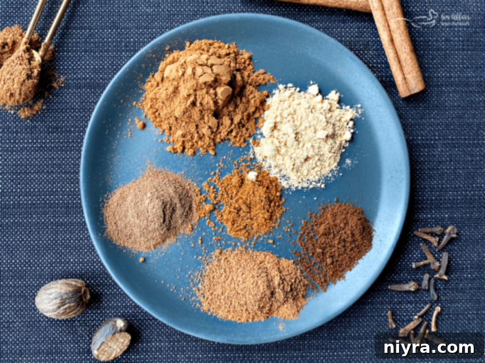 Artisan Pumpkin Pie Spice Mix 6 Close-up of a jar of homemade pumpkin pie spice blend, with a wooden spoon.