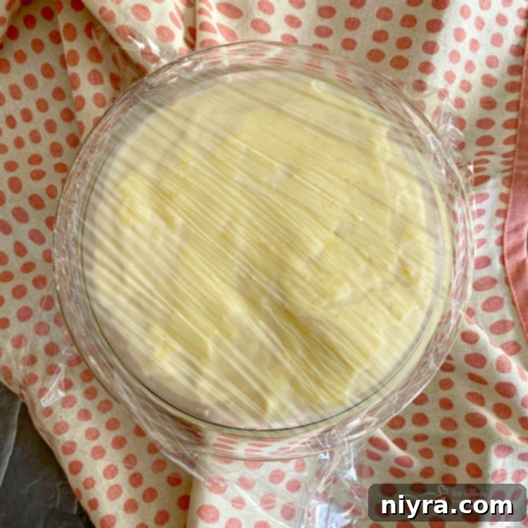 Custard covered with plastic wrap, chilling in the refrigerator