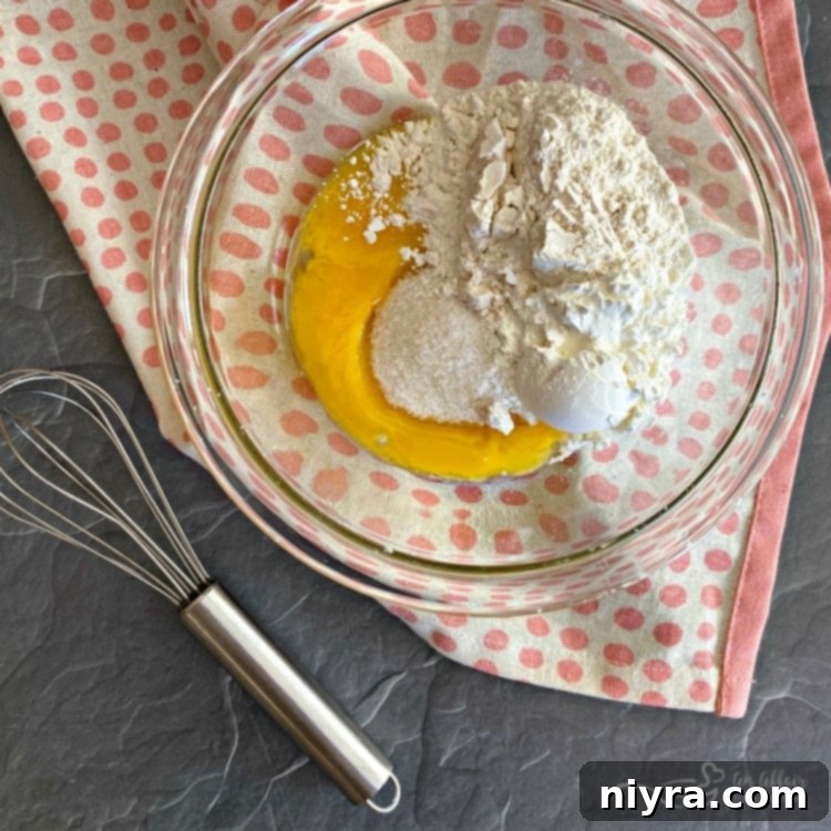 Whisking egg yolks, flour, cornstarch, salt, and half and half in a bowl