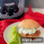 slow cooker buffalo pulled pork sandwich on white plate