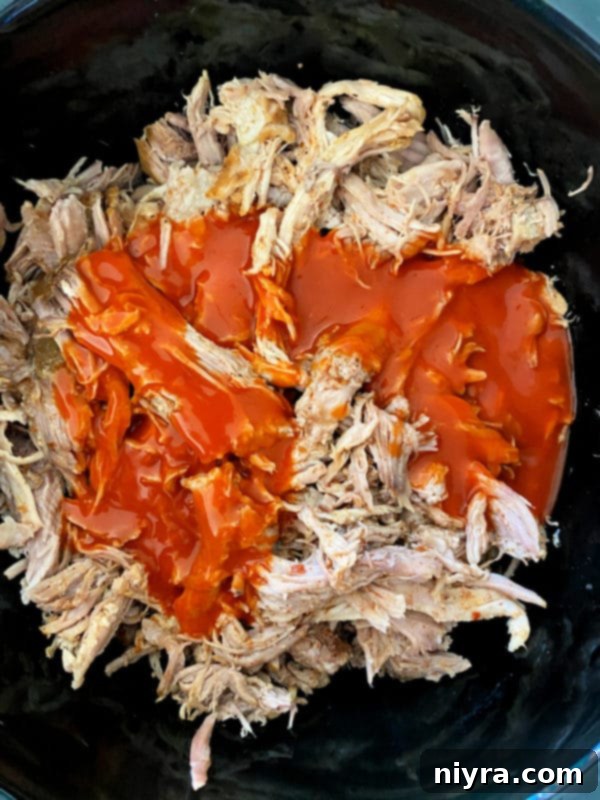 Shredded pork returning to slow cooker with sauce