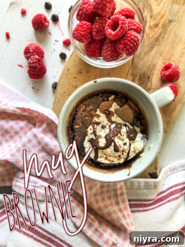 A beautifully presented mug brownie with whipped cream and chocolate shavings.