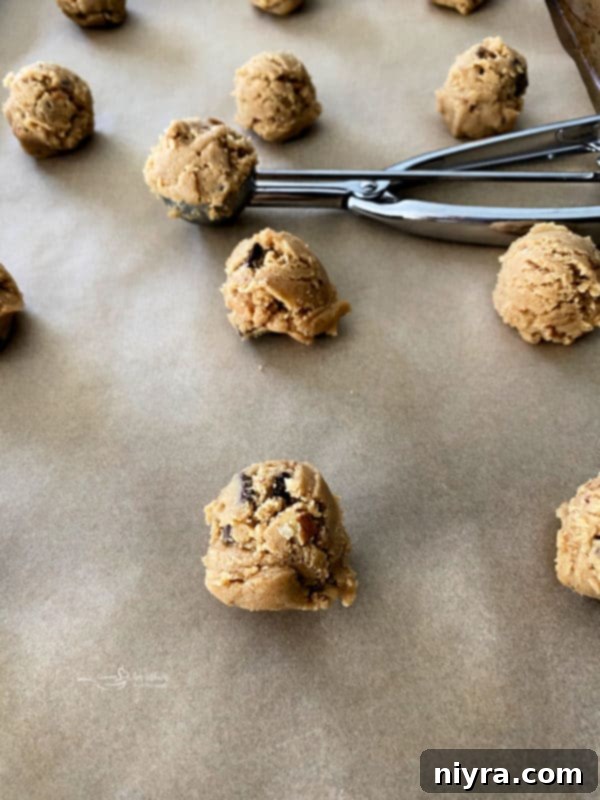 Cookie dough balls scooped onto a baking sheet, ready for the oven.