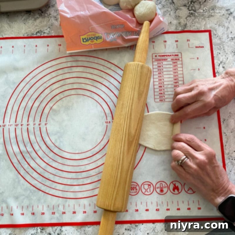Flattening frozen dinner roll dough with a rolling pin