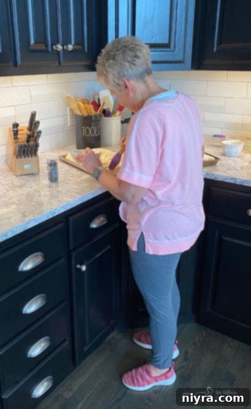 Poppyseed rolls rising on a cookie sheet, covered loosely with plastic wrap