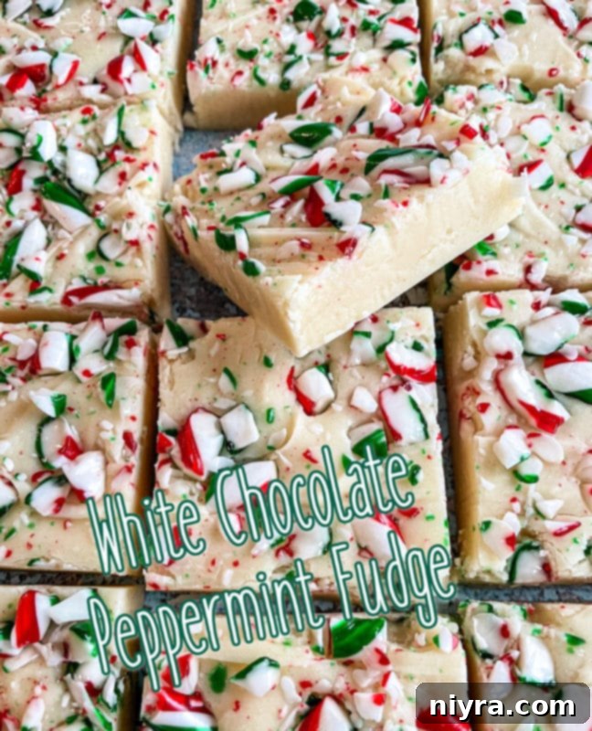 Several pieces of White Chocolate Peppermint Fudge artfully arranged on a dark background, showcasing their festive appeal.