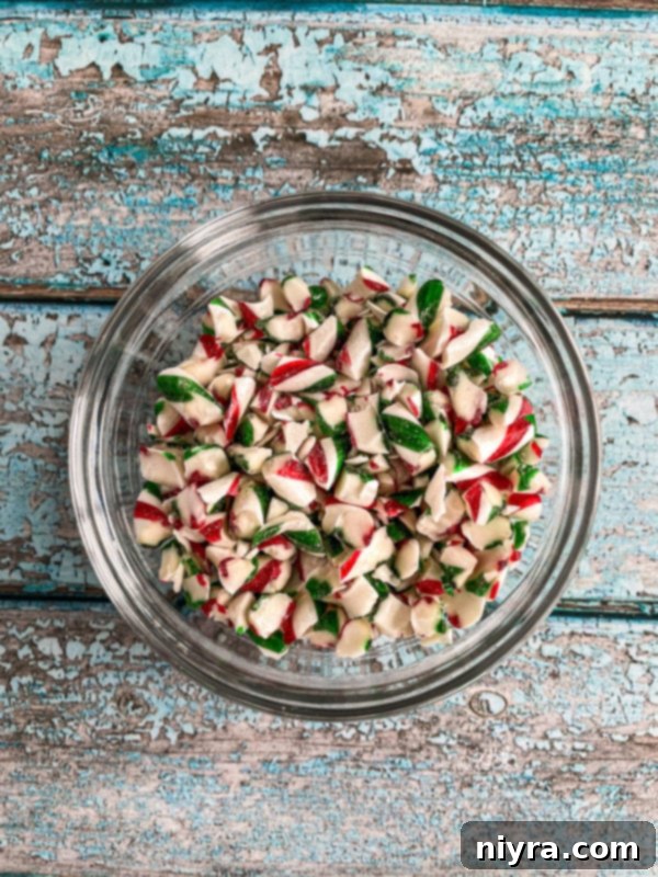 Close-up of a hand pouring the warm fudge mixture into a prepared baking dish.