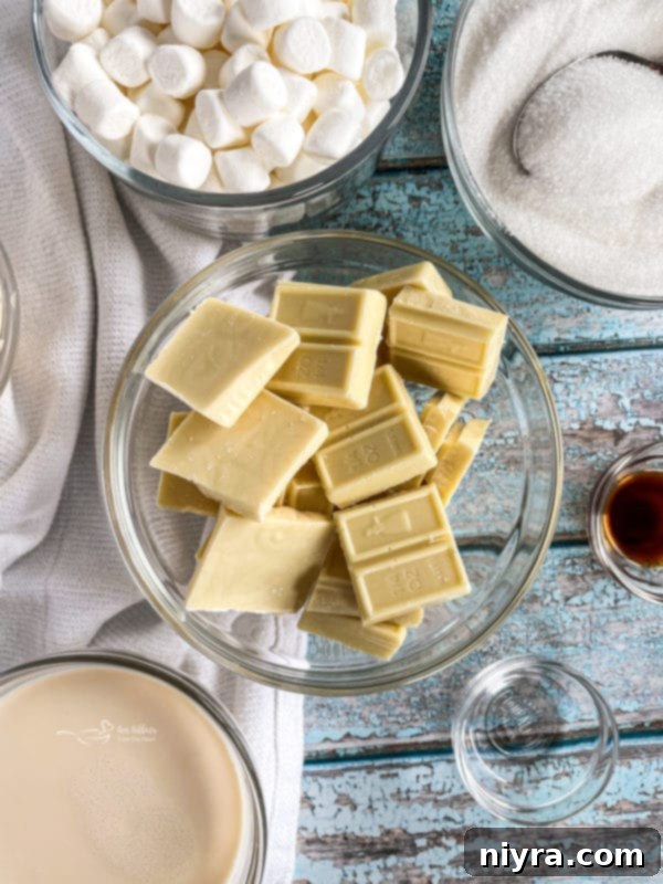 Multiple pieces of White Chocolate Peppermint Fudge on a white platter, garnished with more crushed peppermint.