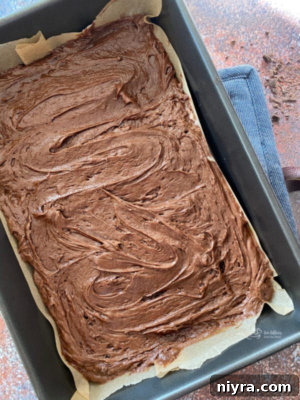 Cookie Dough Brownie Dream 12 Baked brownie base in a parchment-lined pan, ready for chilling