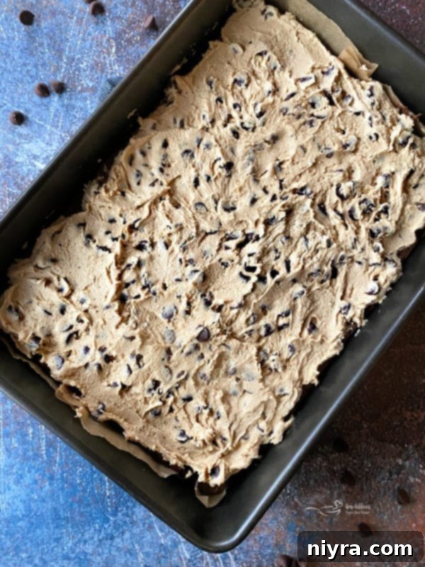 Cookie Dough Brownie Dream 14 Spreading edible chocolate chip cookie dough over chilled brownies with a rubber spatula