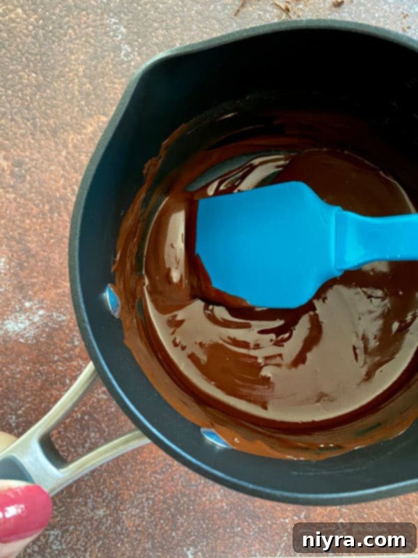 Cookie Dough Brownie Dream 9 Melted dark chocolate in a saucepan, ready to be incorporated into the brownie batter