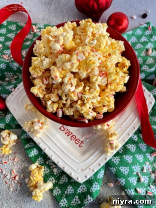 Close up of a bowl of Peppermint Bark Popcorn, garnished with candy canes.