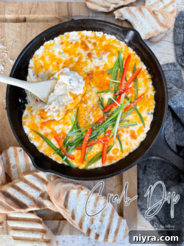 Image of a Slow Cooker Crab Dip being served on a cutting board with crackers.