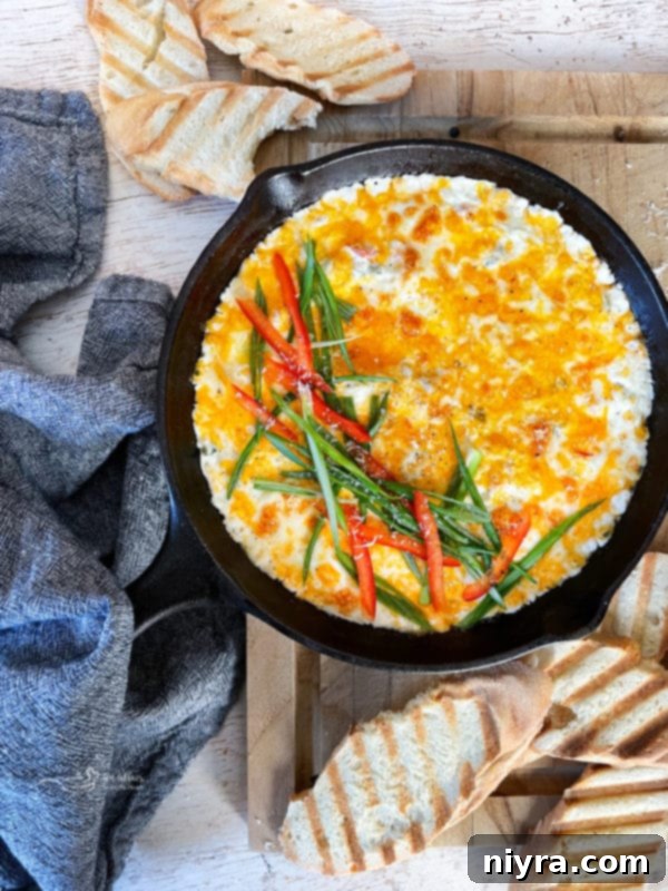 Slow Cooker Crab Dip served elegantly in a cast iron skillet with toasted baguette slices.