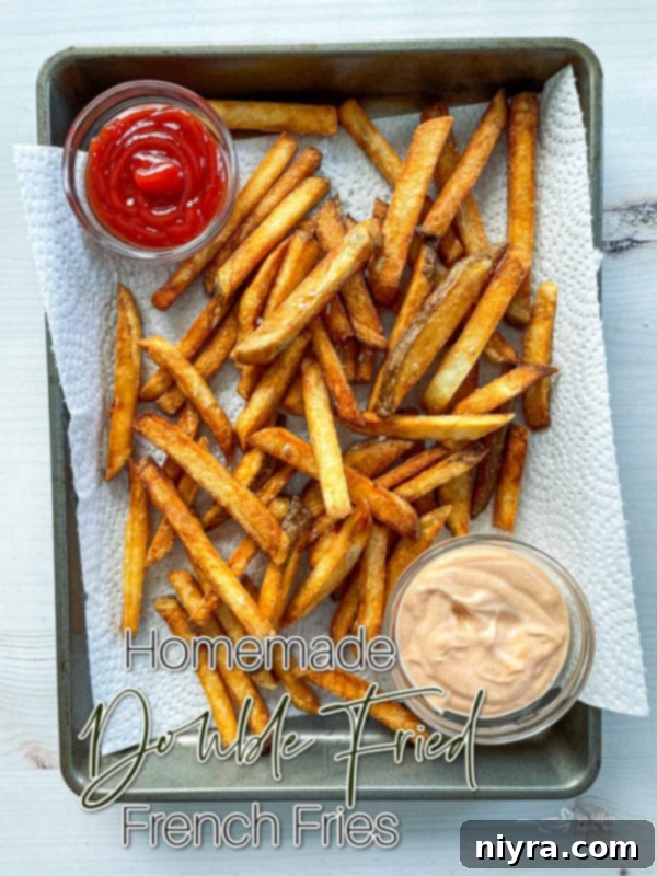 Perfectly Crispy Homemade French Fries 16 Top view of fries on baking sheet with ketchup, enticing viewers to try the recipe