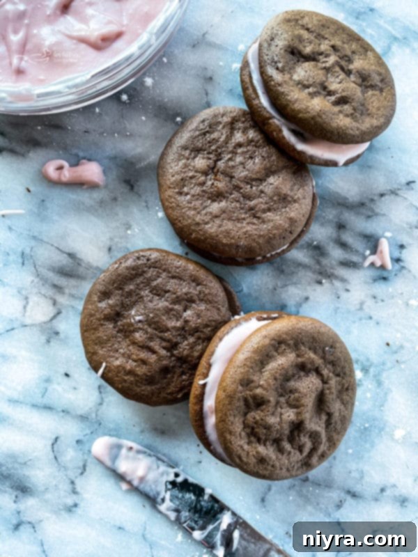 Finished Chocolate Strawberry Whoopie Pies stacked on a cake stand