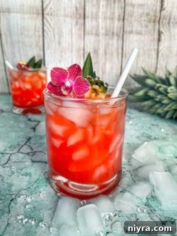 A perfectly prepared Tropical Sparkling Cocktail garnished with pineapple and orange slices