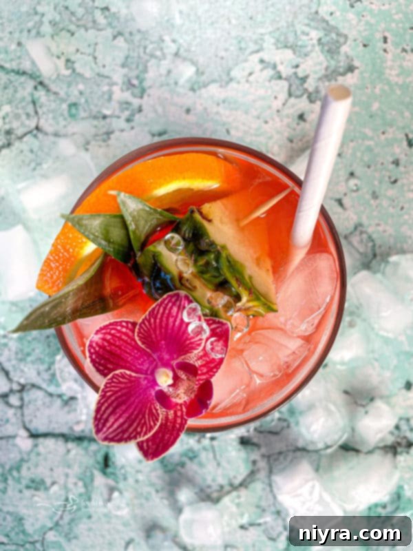 Close-up of a vibrant Tropical Sparkling Cocktail, garnished with fresh fruit and a cocktail pick