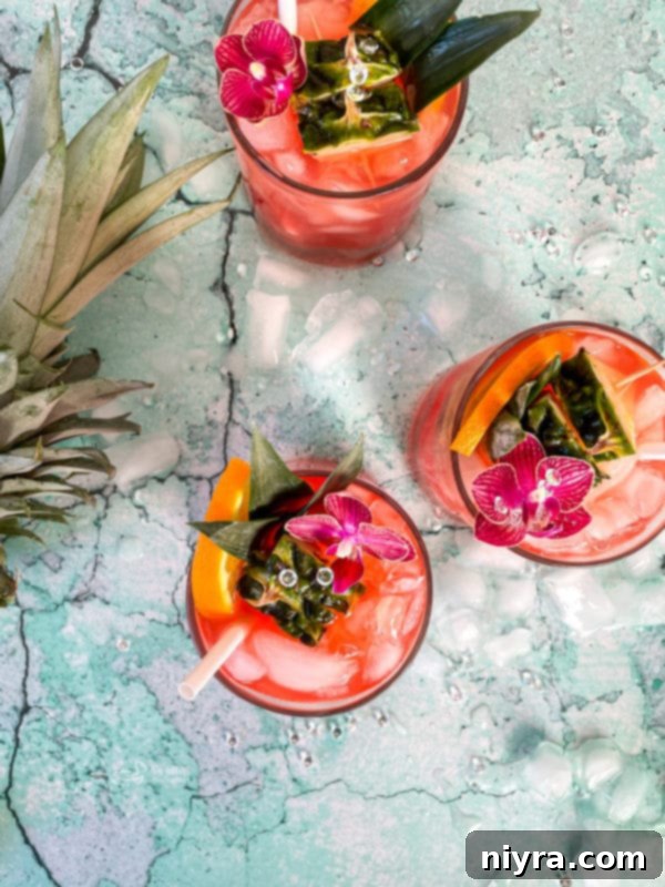 Two glasses of Tropical Sparkling Cocktail on a wooden table, suggesting a relaxed vacation mood