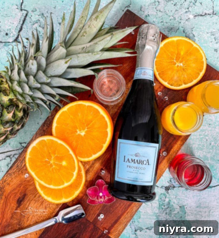 Individual ingredients for Tropical Sparkling Cocktail laid out: orange juice, pineapple juice, coconut rum, grenadine, and Prosecco