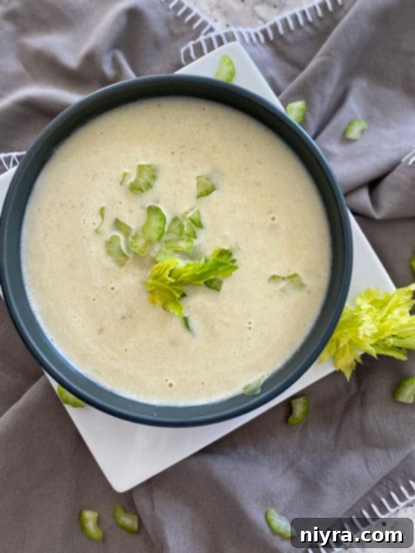 Instant Pot Cream of Celery Soup in a white bowl with fresh celery garnish