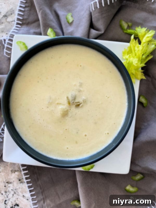 A serving of Instant Pot Cream of Celery Soup with a swirl of cream and fresh parsley