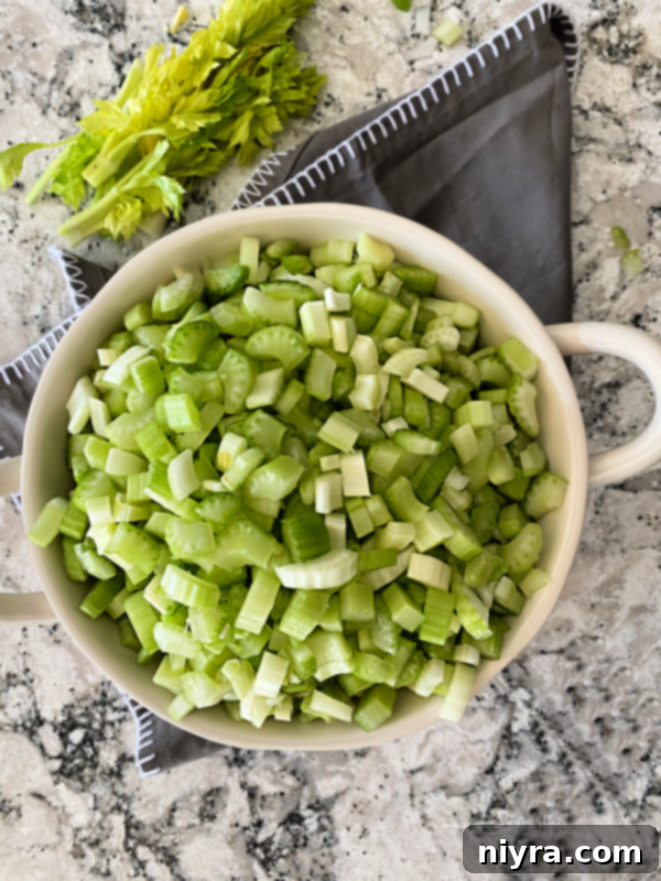 Instant Pot Cream of Celery Soup in a serving bowl with a side of fresh celery sticks