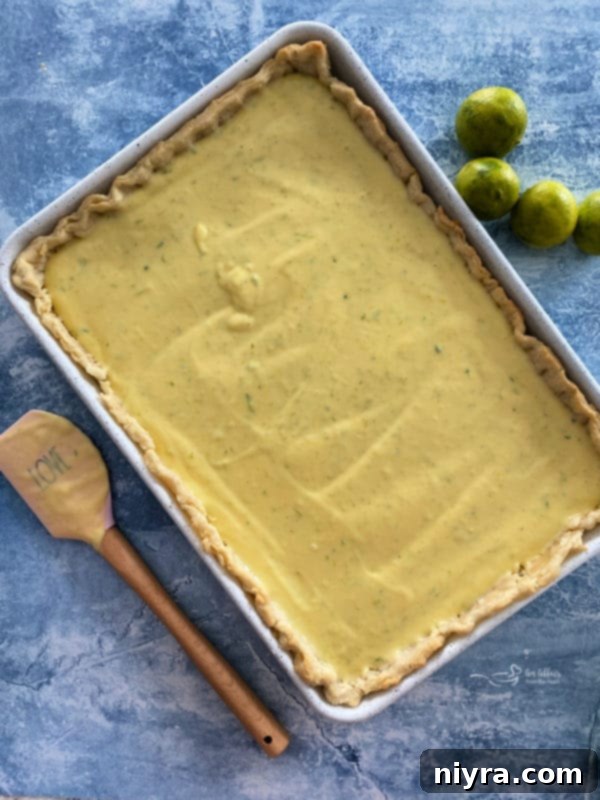A Key Lime Slab Pie freshly out of the oven, with its custard filling set, cooling on a rack.