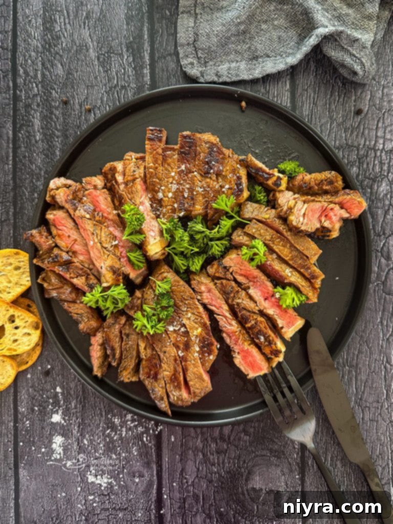 Two Jack and Coke steaks on a grill grate, sizzling.