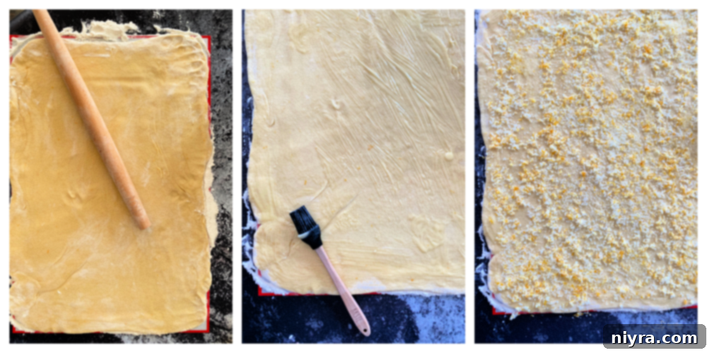Overhead view of lemon sweet roll dough rolled out into a large rectangle on a floured surface, ready for filling