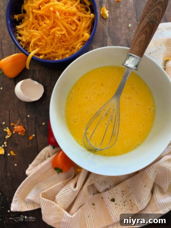 Breakfast sausage and vegetables cooking in a cast iron skillet.