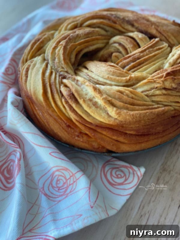 Bloomed Russian Delight 6 Russian rose bread without powdered sugar, resting on a rustic wooden surface, highlighting its natural golden crust.