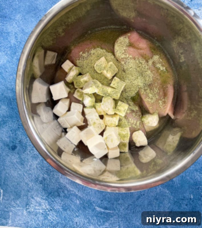 Cubed cream cheese with chicken, chicken broth, and ranch dressing mix