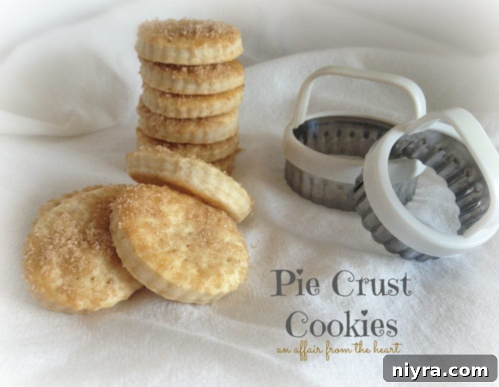 A charming scene with pie crust cookies and various cookie cutters on a white tablecloth, highlighting the fun of baking.