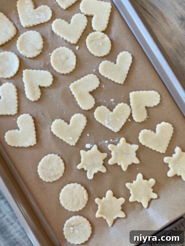Rolled out pie dough on a floured surface, ready for cutting into cookie shapes.