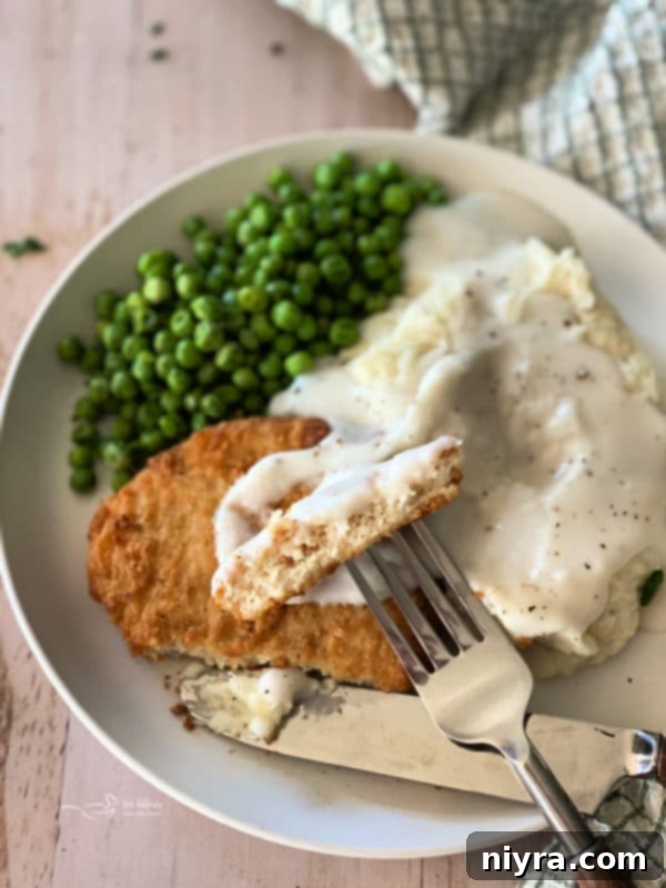 Family gathered around the dinner table, enjoying a meal of chicken, mashed potatoes, and gravy.