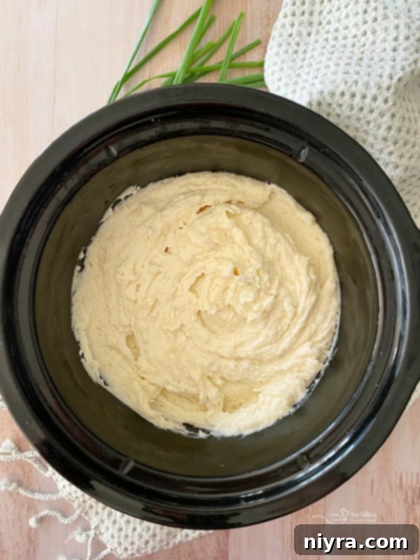 Close-up of fluffy mashed potatoes being kept warm in a slow cooker.