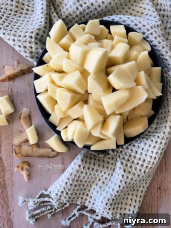 Top view of cubed Russet potatoes in a bowl, prepared for slow cooking.