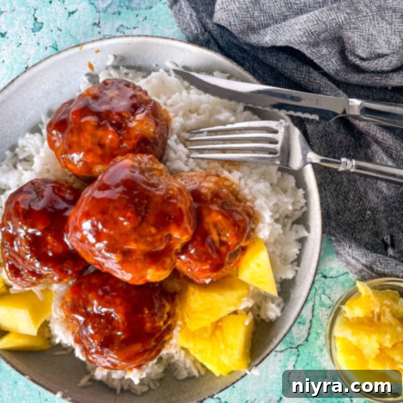 Top view of Hawaiian ham balls in bowl with pineapple chunks and rice