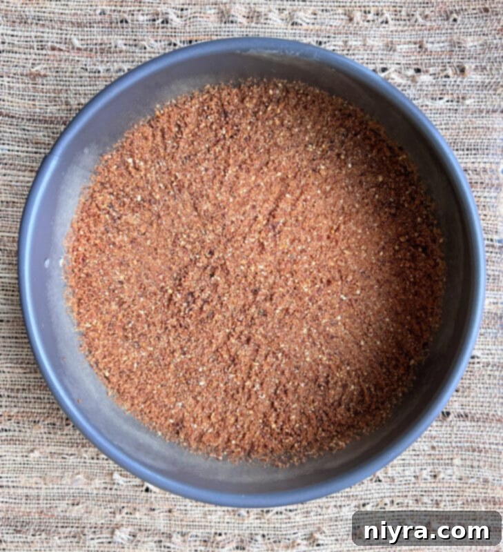 Close-up of the chocolate graham cracker crust mixture in a bowl with a fork