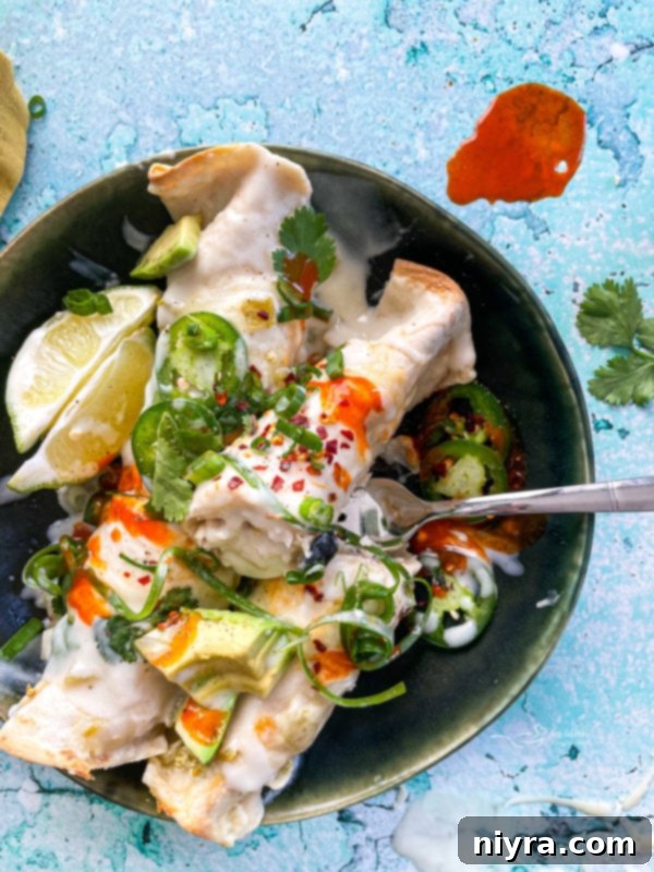 Enchiladas on plate with fork and garnishments