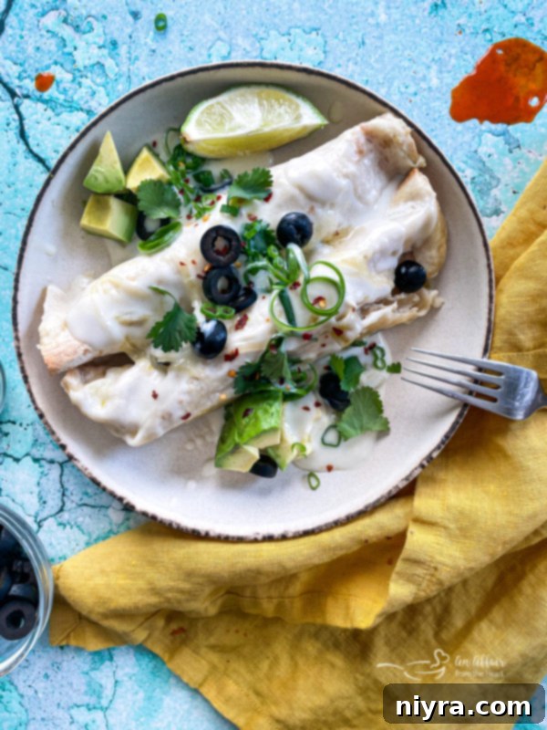 Two enchiladas on plate with fork