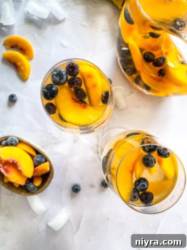 Rose Sangria in a pitcher with glasses and fruit