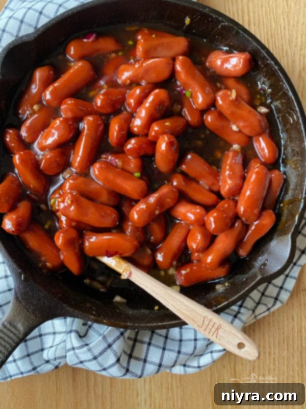 Stirring Dorothy's BBQ Little Smokies in a skillet