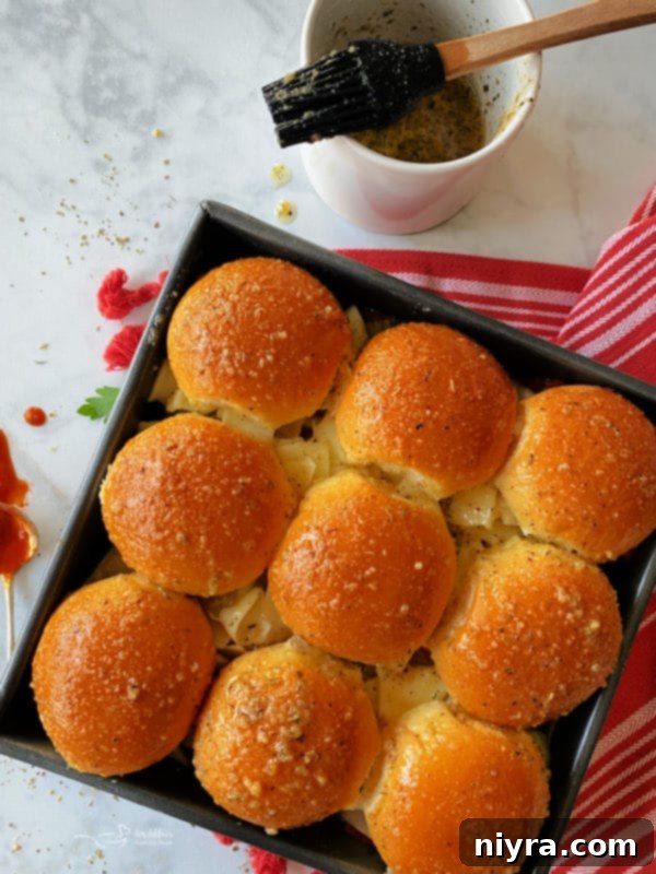 Brushing garlic butter onto Hawaiian slider buns