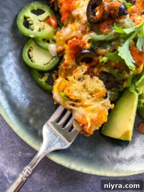 Easy Skillet Tamale Pie Video Tutorial 11 close up of a slice of tamale pie, showing the layers of cornbread, meat, and cheese