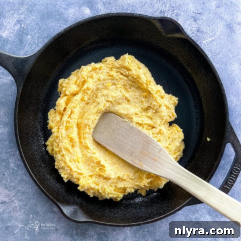 Easy Skillet Tamale Pie Video Tutorial 7 spreading cornbread mixture into a greased cast iron skillet