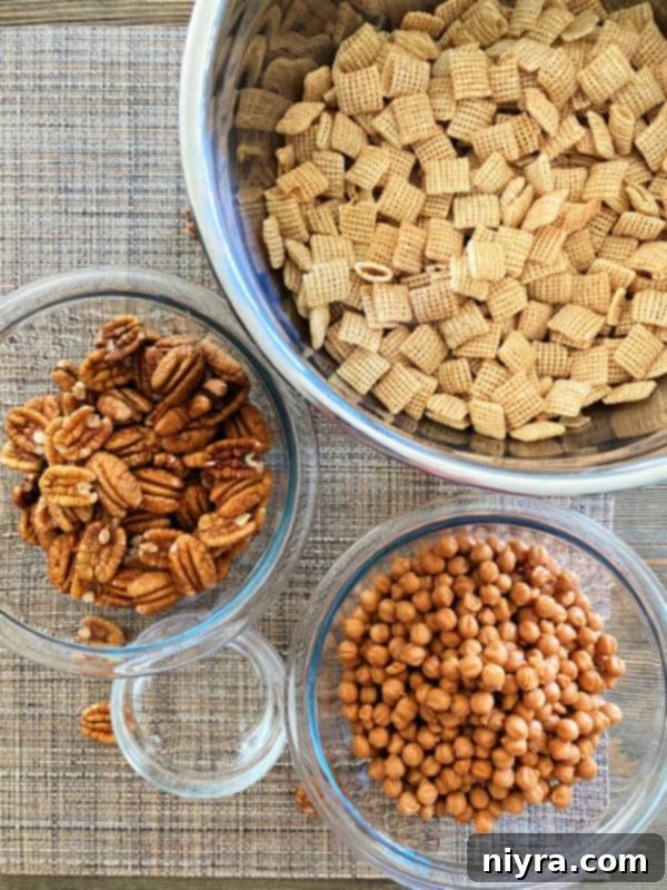Three key ingredients for caramel pecan clusters: pecans, Chex Mix cereal, and caramel bits, laid out for easy viewing.