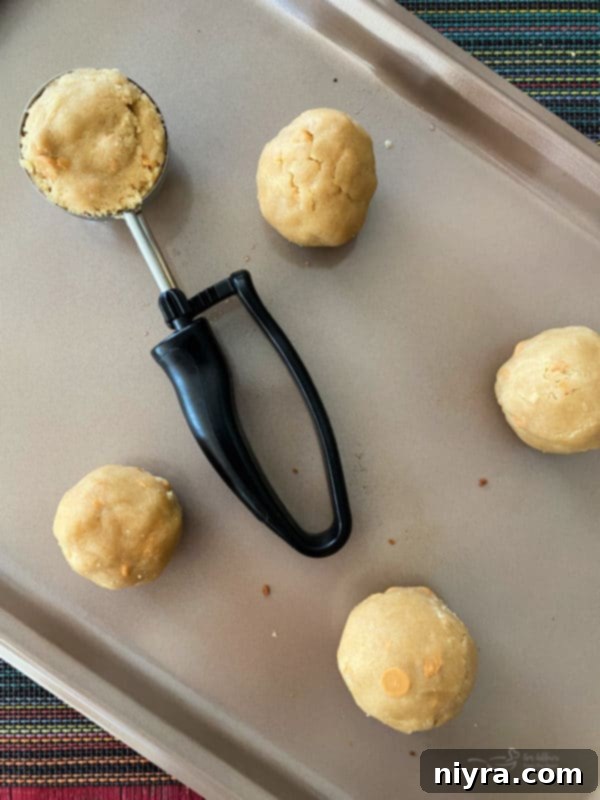 Butterscotch Cookie Dough Balls Overhead view of perfectly rounded giant butterscotch cookie dough balls, spaced out on a baking sheet, ready for the oven.